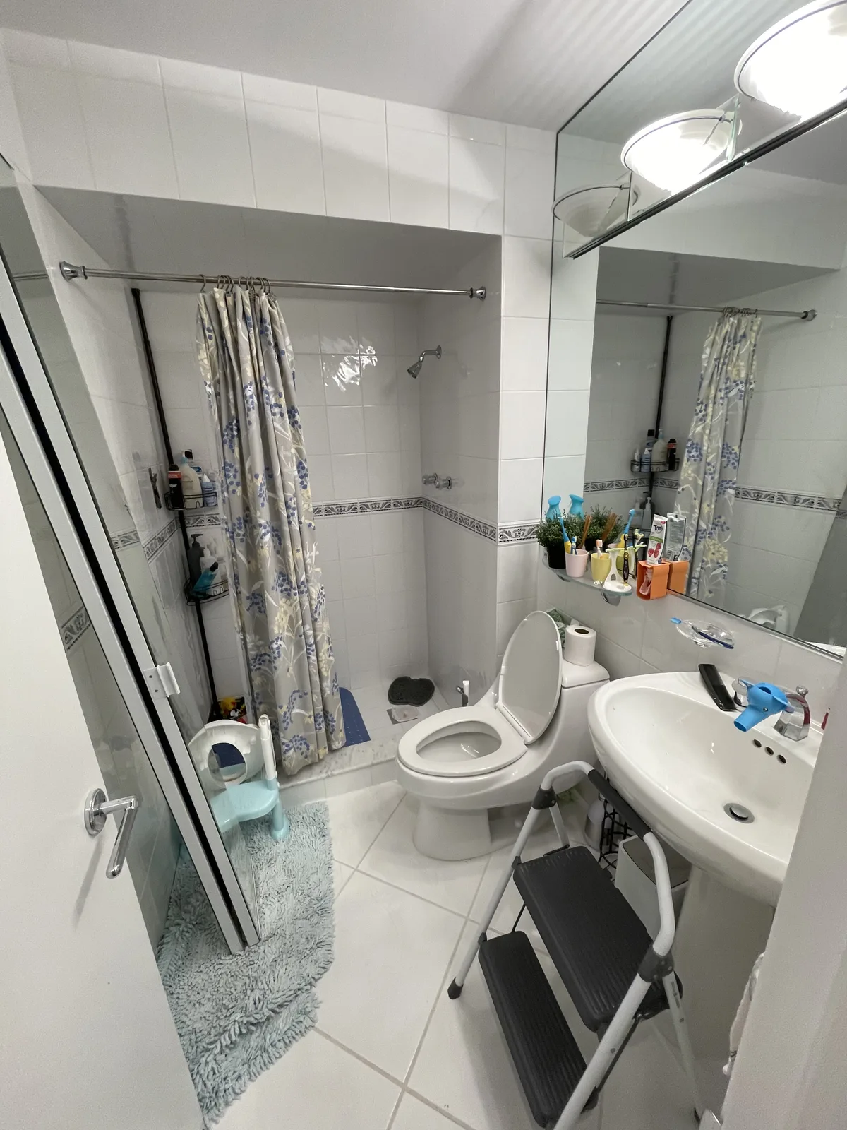 Before — Small bathroom remodel with marble tile, navy vanity and LED mirror in Weston, Broward County