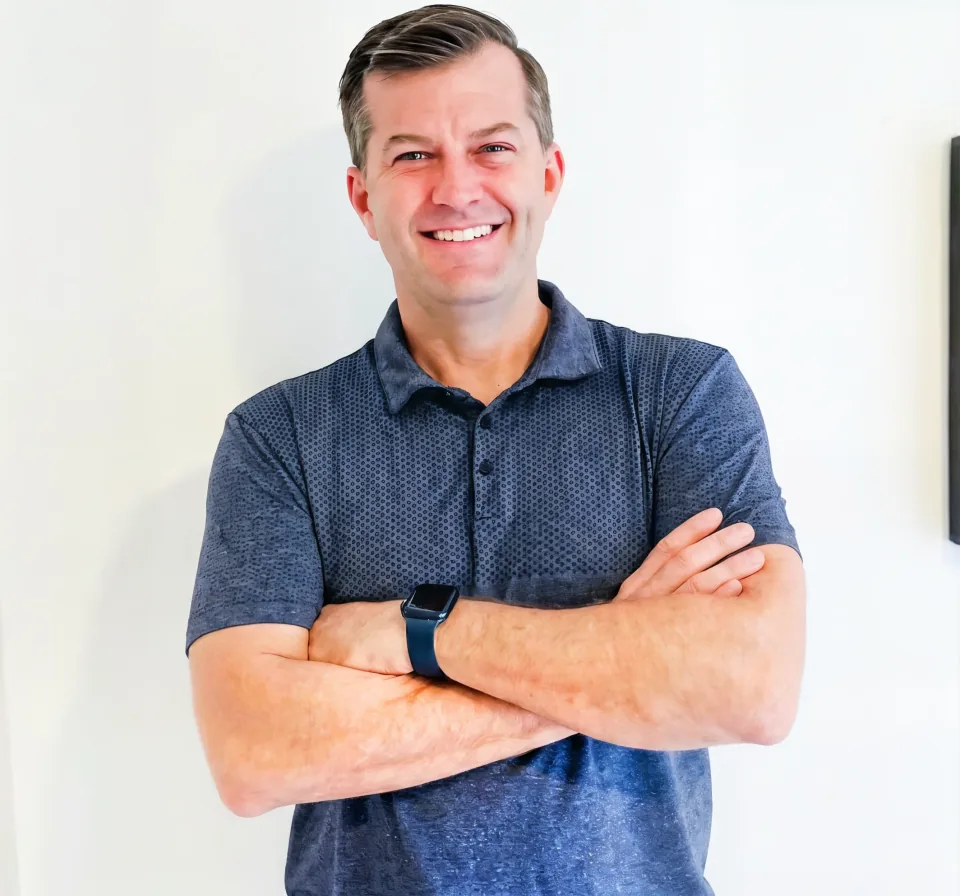 Brad Pleimann, owner of Repair and Remodel, arms crossed in a blue polo shirt