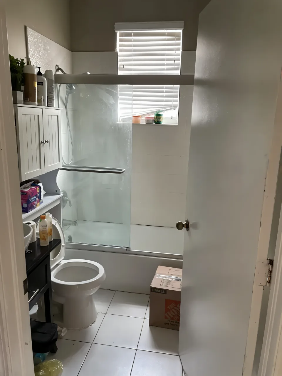 Bathroom with an old tub and shower curtain before the accessibility conversion
