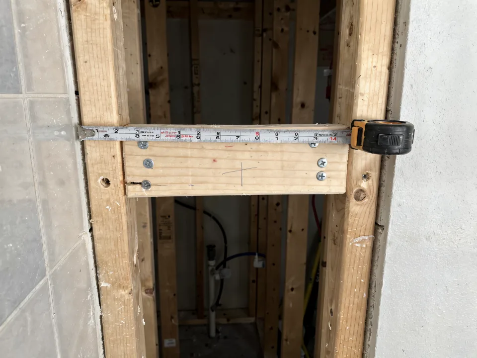 Open bathroom wall with solid wood blocking screwed between the studs at grab-bar height