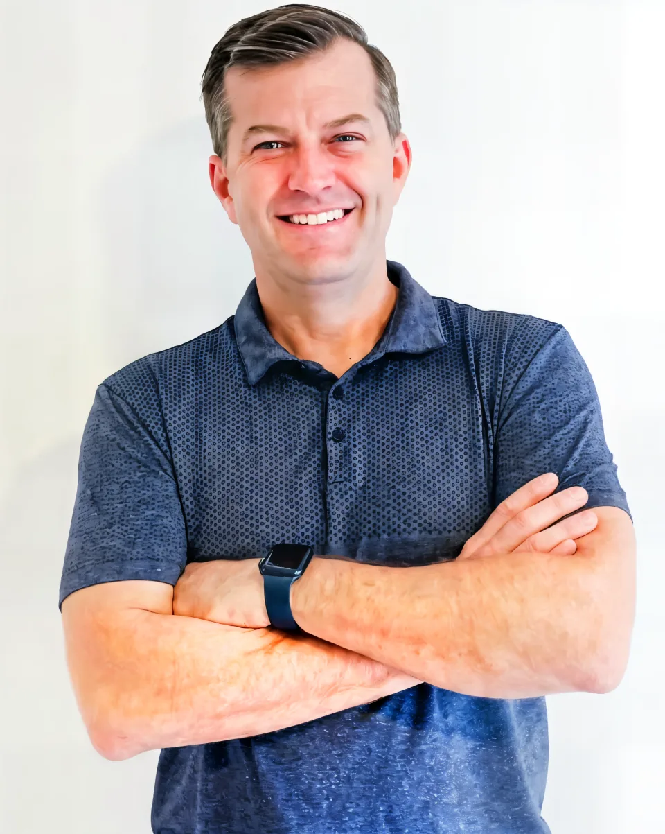 Brad Pleimann, owner of Repair and Remodel, arms crossed in a blue polo shirt