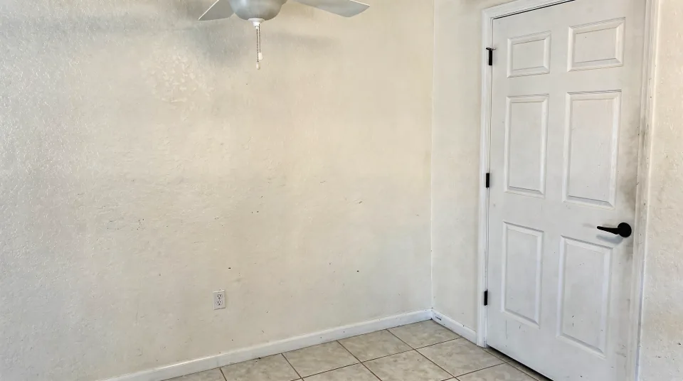 Repaired and repainted hallway with a new six-panel door, new baseboard and a ceiling fan